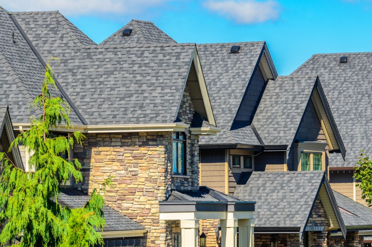 Stone townhomes with grey asphalt roofing