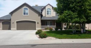 Light brown house with tree in front yard
