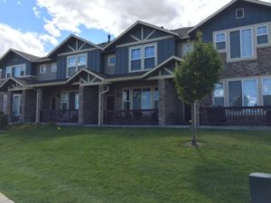 Stone front apartment complex with blue siding