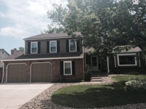 Dark brown house with black shudders