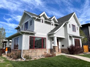 unique styled home with new light gray paint on house with red windows and door Vivax Pros House Painters