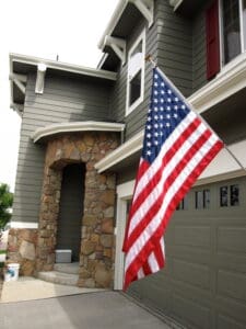 recently painted home with American Flag hanging near garage Vivax Pros