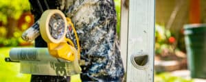 close up of painter standing near ladder with white paint on his pants Vivax Pros